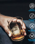 Hand holding a glass of alcohol-free Driftology nightcap with ice cubes on a dark background, featuring icons about product benefits.